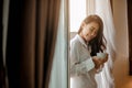 Young woman asia living at home relaxing and drinking cup of hot coffee in the bedroom on holiday. Royalty Free Stock Photo