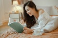 Young woman asia living at home relaxing and reading a book in the bedroom on holiday Royalty Free Stock Photo