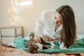 Young woman asia wake up refreshed in the morning playing with cats at bed happily on holiday. Royalty Free Stock Photo