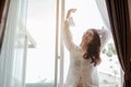 Young woman asia living at home relaxing and drinking cup of hot coffee in the bedroom on holiday. Royalty Free Stock Photo