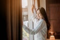 Young woman asia living at home relaxing and drinking cup of hot coffee in the bedroom on holiday. Royalty Free Stock Photo