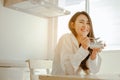 Young woman asia wake up refreshed in the morning and relaxing eat coffee, cornflakes, bread and apple for breakfast at house on h Royalty Free Stock Photo