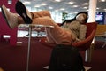 Young woman asleep with mask inside the international airport waiting for her departure flight to her vacation destination, she is Royalty Free Stock Photo