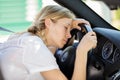 young woman asleep slumped over wheel car