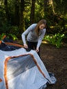 Young woman assembles a camping tent in the forest. Travel and Leisure