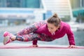 Young woman in Astavakrasana pose against the city and river Royalty Free Stock Photo