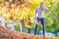 Young woman athlete runner tired breathing after running in a beautiful colorful autumn park