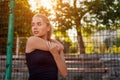 Young woman athlete warming up before running on sportsground in summer. Active lifestyle