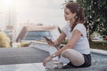 Young woman athletes in sportswear sitting in park, relax after sports training, use smartphone, listen to music. Royalty Free Stock Photo