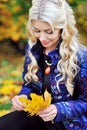 Young woman with autumn leaves in hand and fall yellow maple gar Royalty Free Stock Photo