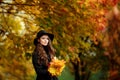 Young woman with autumn leaves in hand and fall yellow maple garden background Royalty Free Stock Photo