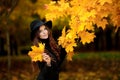 Woman with autumn leaves in hand and fall yellow maple garden background Royalty Free Stock Photo