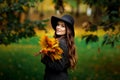 Woman with autumn leaves in hand and fall yellow maple garden background Royalty Free Stock Photo