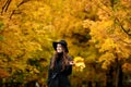 Woman with autumn leaves in hand and fall yellow maple garden background Royalty Free Stock Photo