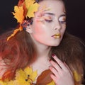 Young woman with autumn make up and leaves on head and her body Royalty Free Stock Photo