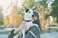 young woman in autumn outfit holding her dog and embracing him. hugging loving pet. owner and jack russell terrier on a