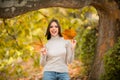 Young woman in autumn park. Warm sunny weather. Fall concept. Hello autumn. Happy woman with autumn yellow leaves Royalty Free Stock Photo