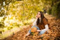 Young woman in autumn park. Warm sunny weather. Fall concept. Hello autumn. Happy woman with autumn yellow leaves Royalty Free Stock Photo