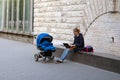 Young woman with baby carriage working on laptop Royalty Free Stock Photo