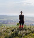 Young woman from back standing on lookout in fitness outfit looking to valley. Palava, Czech republic Royalty Free Stock Photo