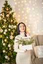 Young woman on the background of the Christmas tree close-up. Woman with fir branches in a knitted dress Royalty Free Stock Photo