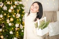 Young woman on the background of the Christmas tree close-up. Woman with fir branches in a knitted dress Royalty Free Stock Photo