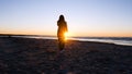 A young woman on the background of the sunset the sun on the seashore does exercises exercised by running, stretching and slumping