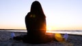 A young woman on the background of the sunset the sun on the seashore does exercises exercised by running, stretching and slumping