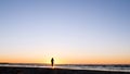 A young woman on the background of the sunset the sun on the seashore does exercises exercised by running, stretching and slumping