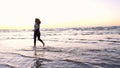 A young woman on the background of the sunset the sun on the seashore does exercises exercised by running, stretching and slumping