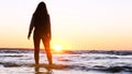 A young woman on the background of the sunset the sun on the seashore does exercises exercised by running, stretching and slumping Royalty Free Stock Photo