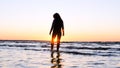 A young woman on the background of the sunset the sun on the seashore does exercises exercised by running, stretching and slumping Royalty Free Stock Photo