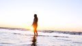 A young woman on the background of the sunset the sun on the seashore does exercises exercised by running, stretching and slumping Royalty Free Stock Photo