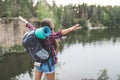 young woman with backpack celebrating freedom on nature while looking