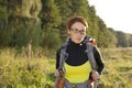 Young woman with backpack in a meadow. Hiking at summertime.