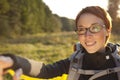 Young woman with backpack in a meadow showing way . Hiking at summertime.