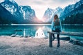 Young woman with backpack is sitting near mountain lake Royalty Free Stock Photo