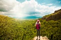 Young woman with backpack standing on cliff edge Royalty Free Stock Photo