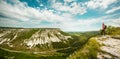 Young woman with backpack standing on cliff edge Royalty Free Stock Photo