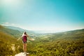 Young woman with backpack standing on cliff edge Royalty Free Stock Photo