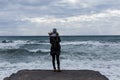 Young woman with backpack standing on cliff`s edge Royalty Free Stock Photo