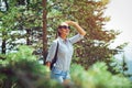 Young woman with backpack standing on cliff`s edge and looking to a sky Royalty Free Stock Photo