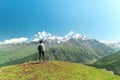 Young woman with backpack standing on top of cliff edge and looking to landscape Royalty Free Stock Photo