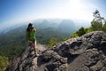 Backpacker climbing to mountain top on cliff edge Royalty Free Stock Photo