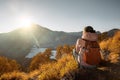 Young woman with backpacker enjoying sunrise view at high mountains. Royalty Free Stock Photo