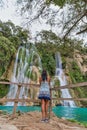 young woman backpacker looking at the waterfall in jungles. Ecotourism concept image travel girl