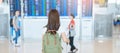 Young woman with bag and luggage looking to flight time information board in international airport, before check in. Travel,