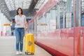 Young woman with baggage at a train station. Caucasian tourist waiting her express train Royalty Free Stock Photo