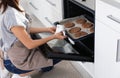 Young woman baking cookies in oven at home Royalty Free Stock Photo