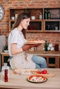 Young woman baking delicious pizza to her family Royalty Free Stock Photo